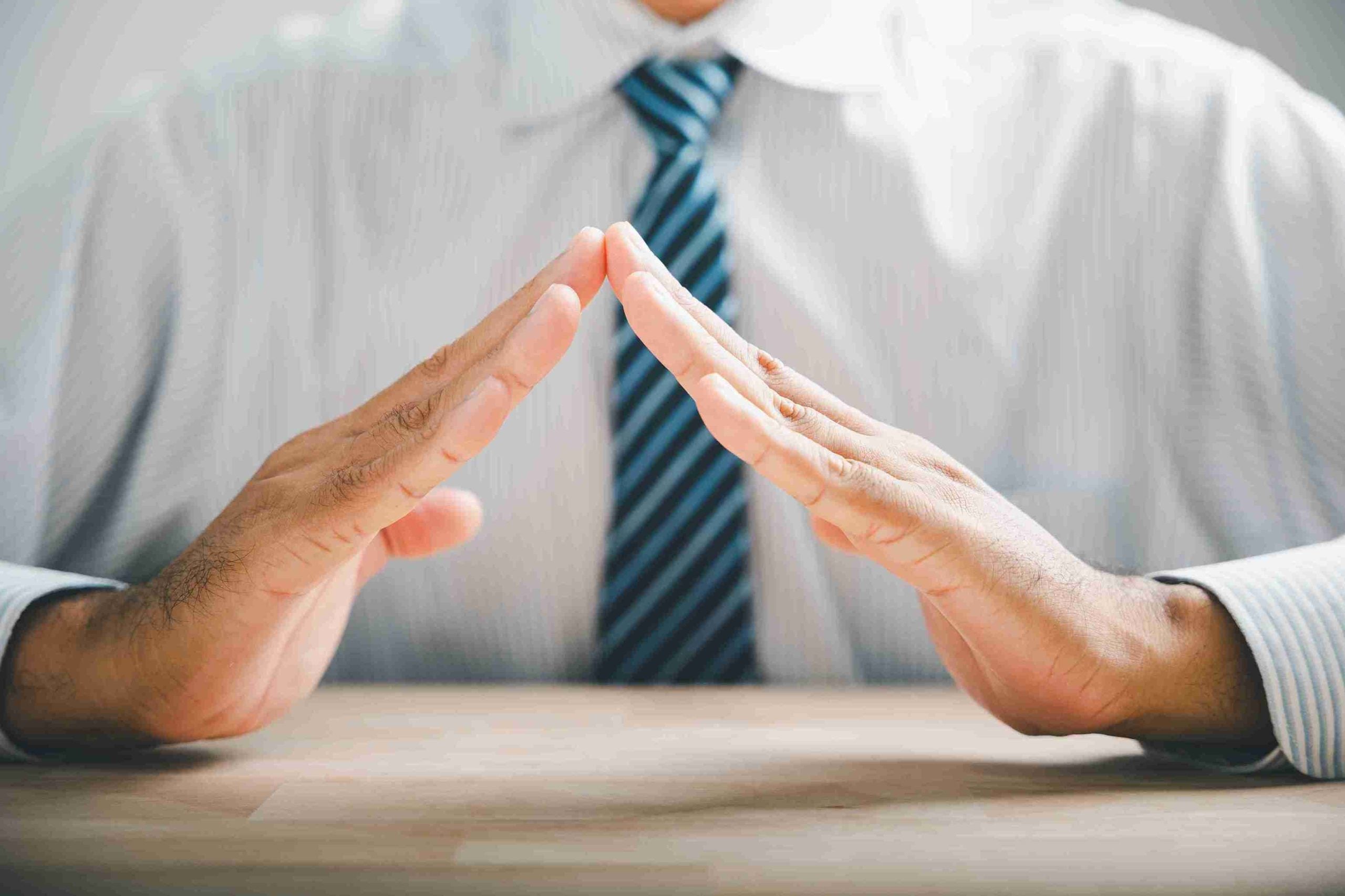 Close up of hands forming a protective roof over.