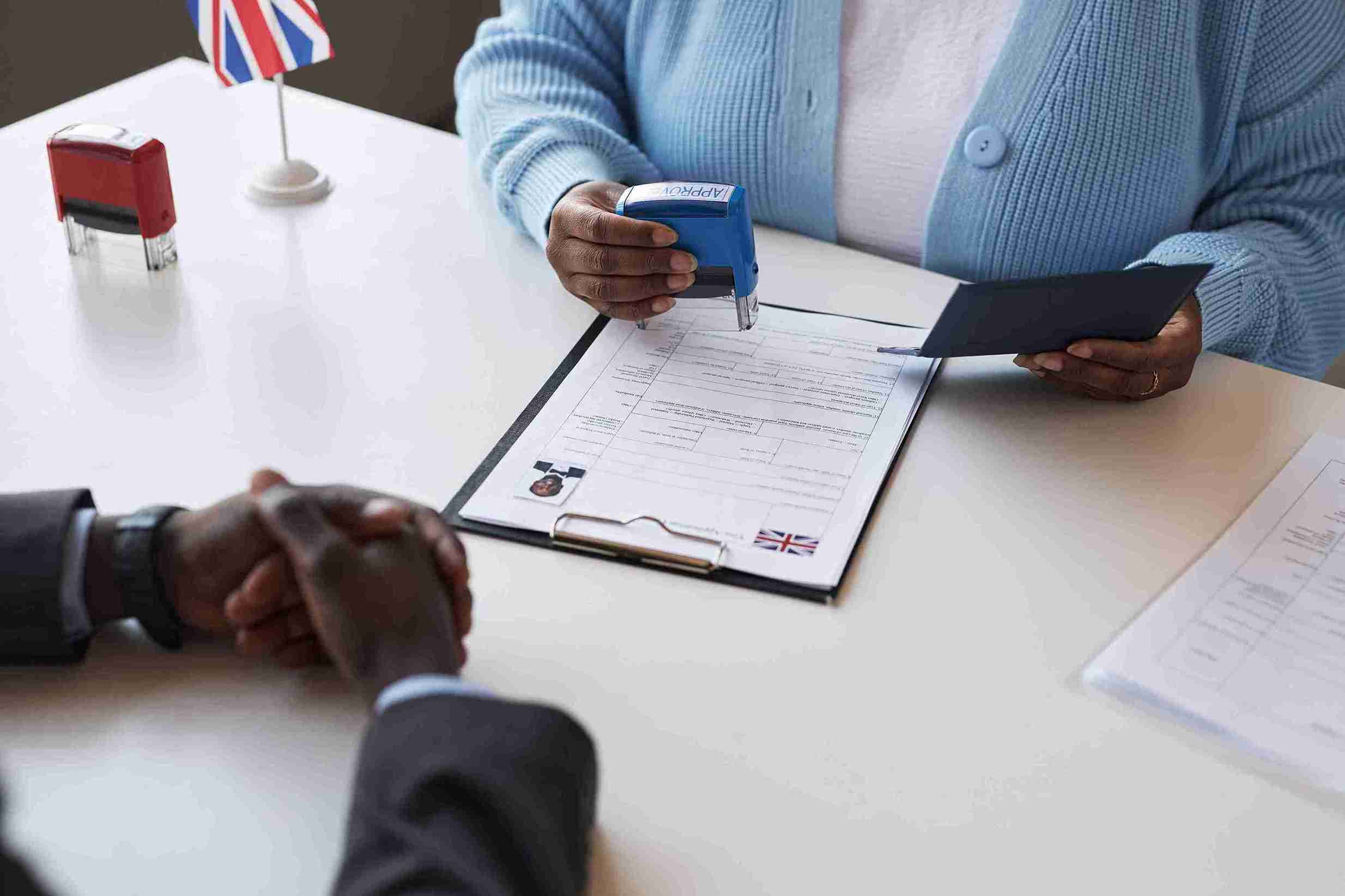 A lady is approving and application in office setting.
