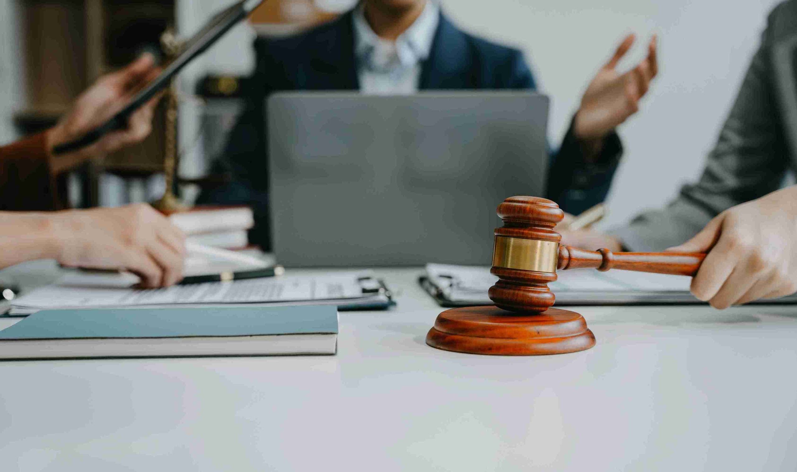 Lawyers discussing a case with a gavel on table.
