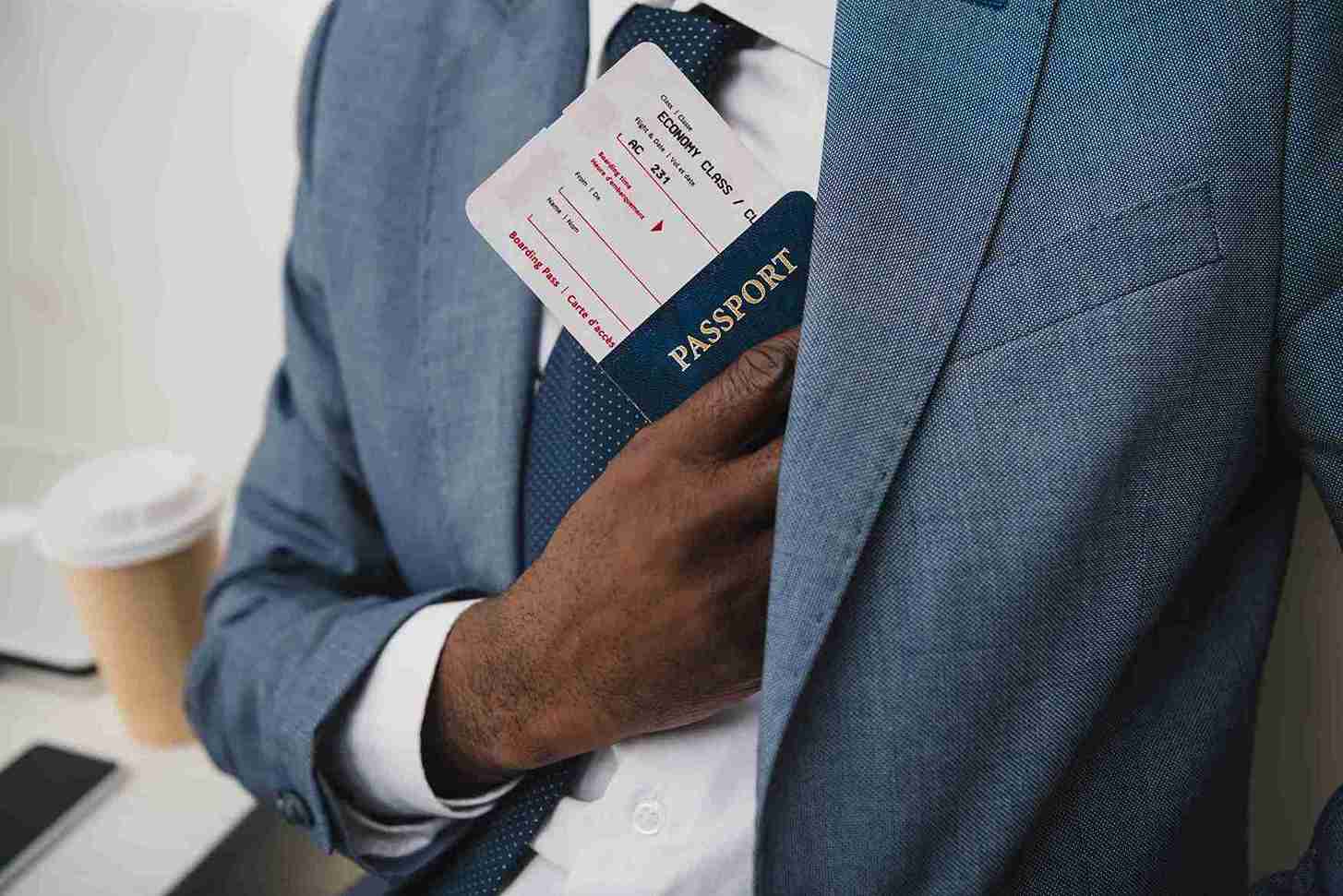 A young business professional holding an Innovator founder visa showing passport and ticket.