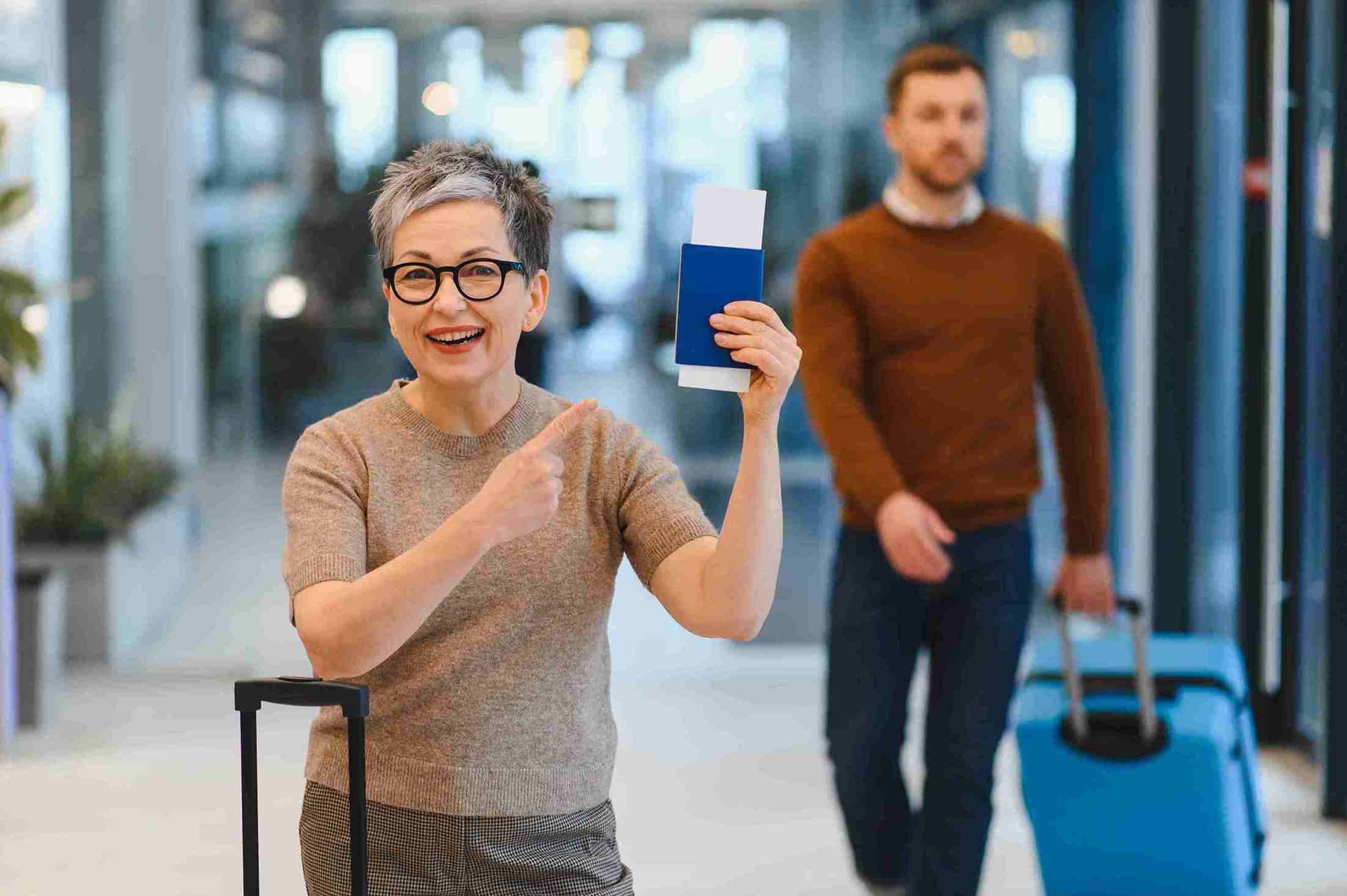 Smiling mature women traveling with passport.