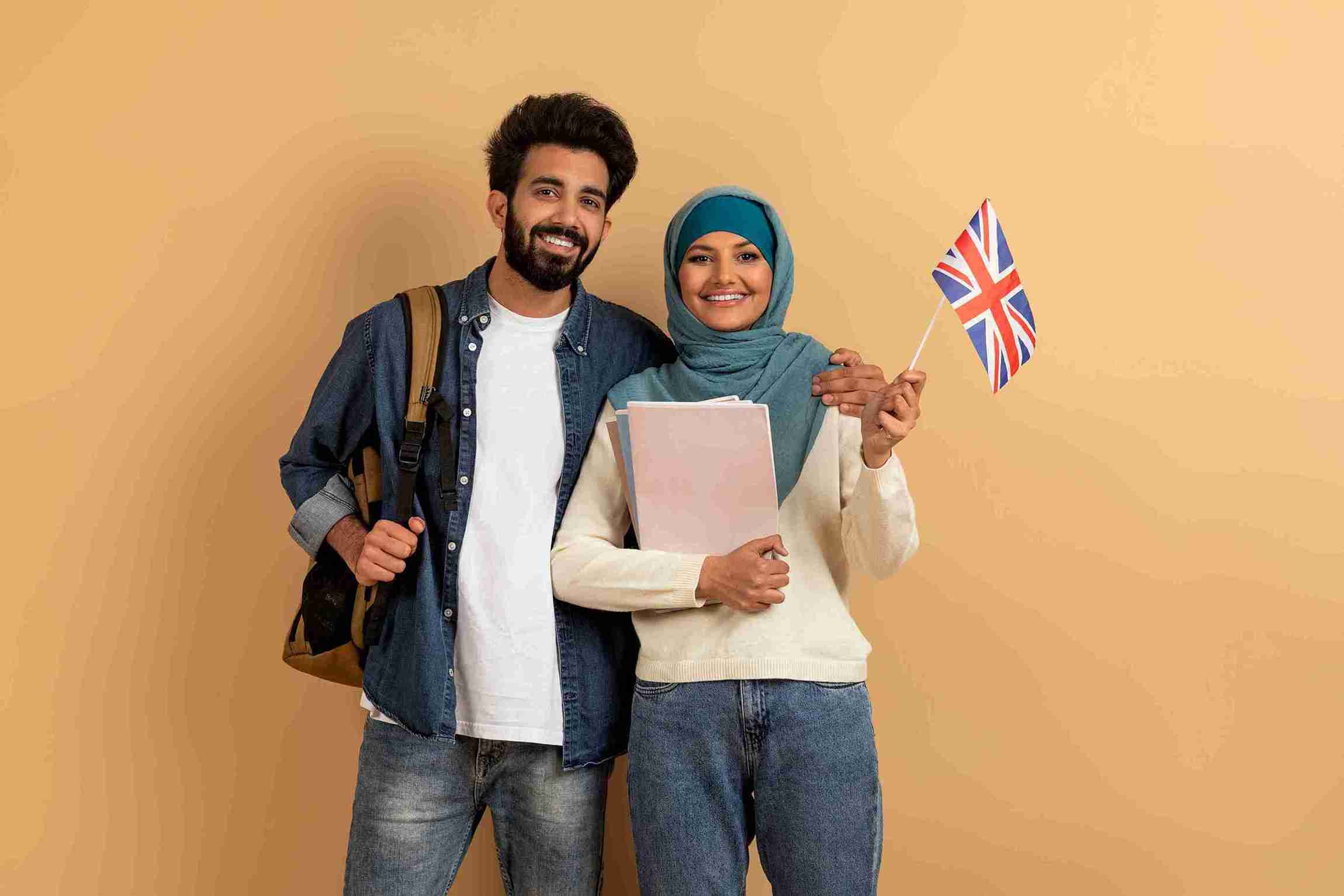 Smiling student holding UK flag.