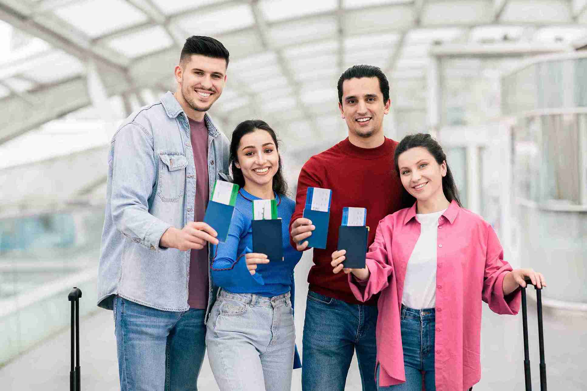 Young couple and friends having their family visa British Passport and ticket in hands.